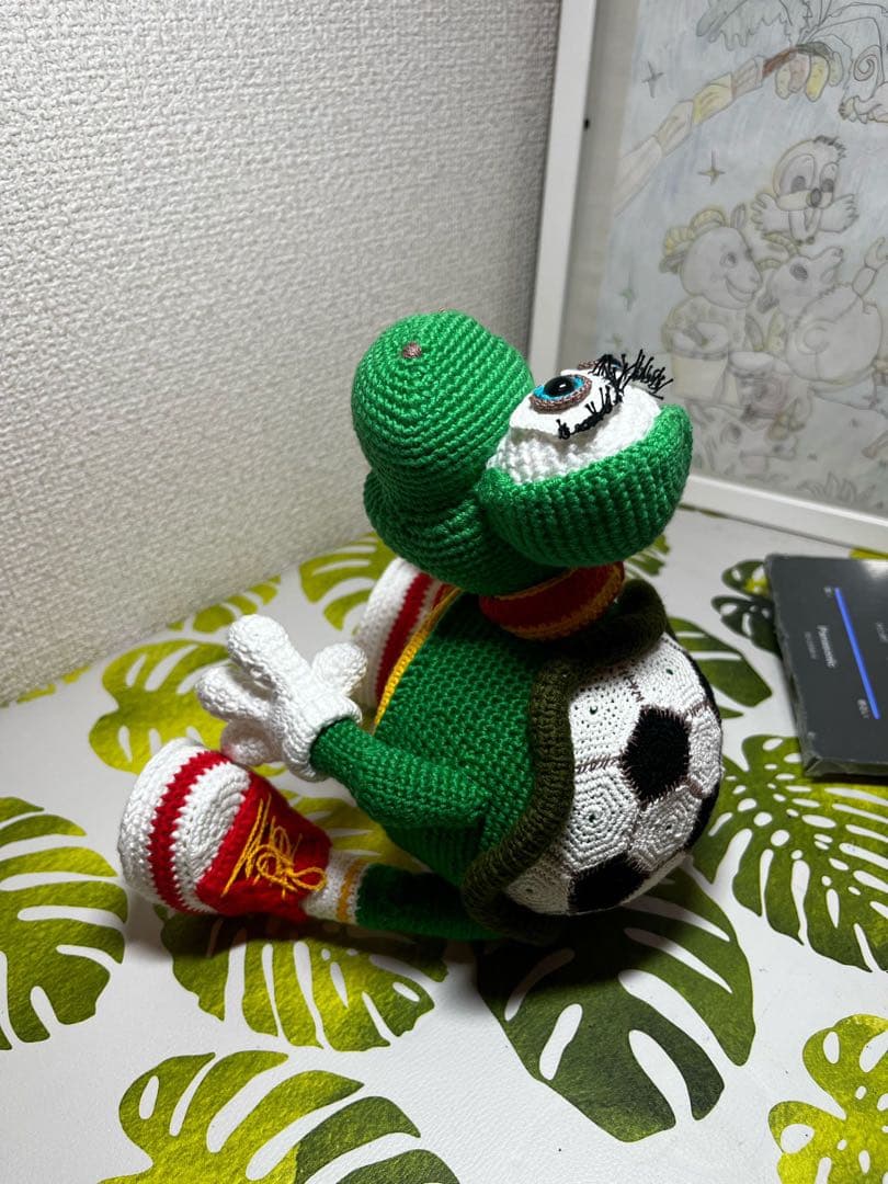 サッカーボールを持つ編み物カメのぬいぐるみ