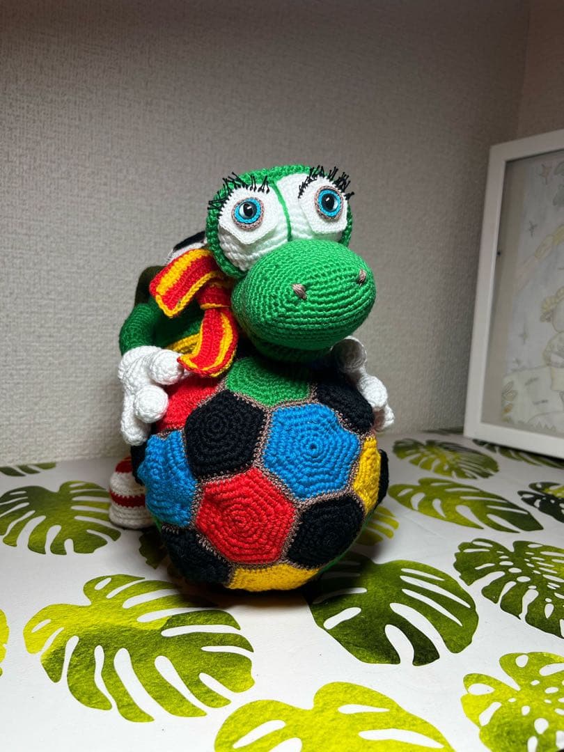 サッカーボールを持つ編み物カメのぬいぐるみ