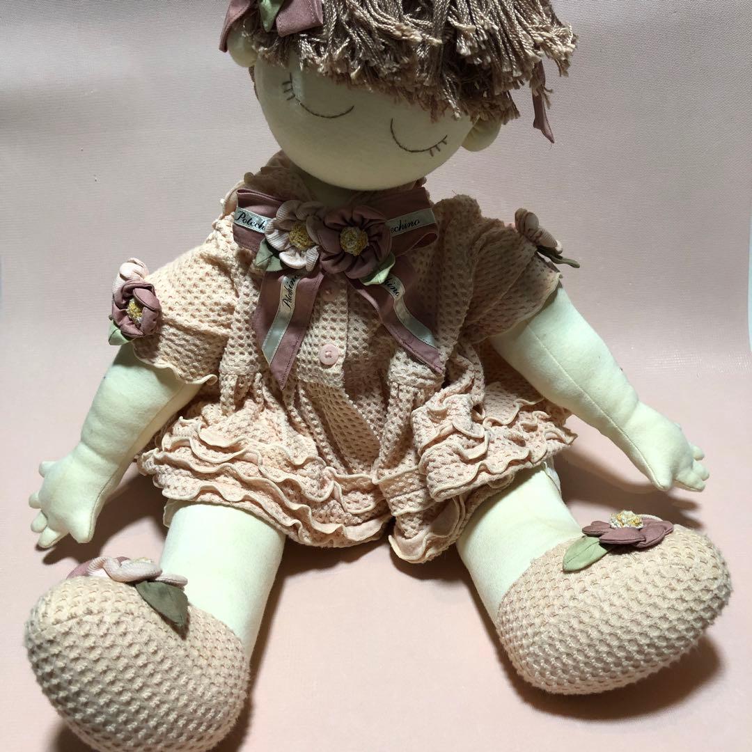 ポテチーノピンクの服を着た三つ編みのお人形の女の子