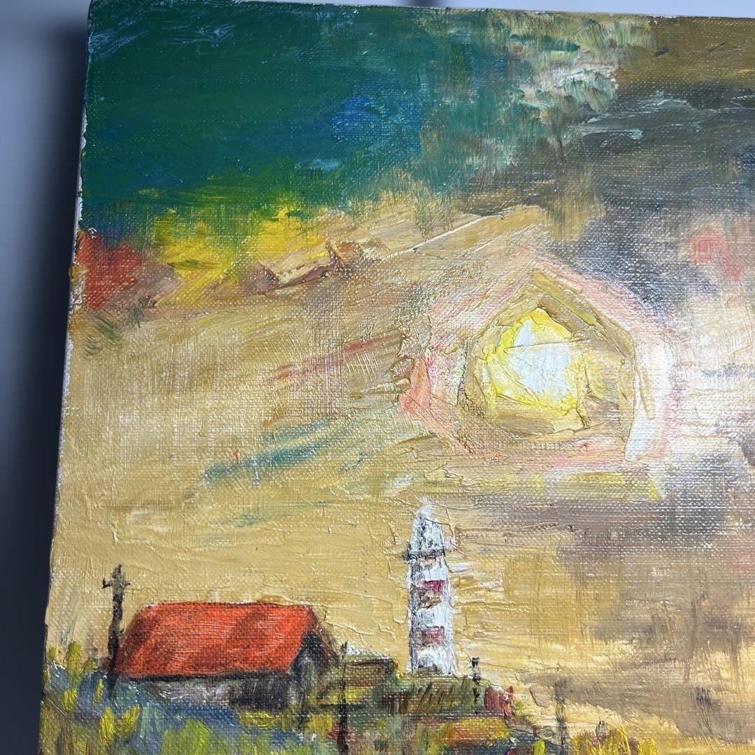 灯台と赤い屋根の建物が描かれた油彩画