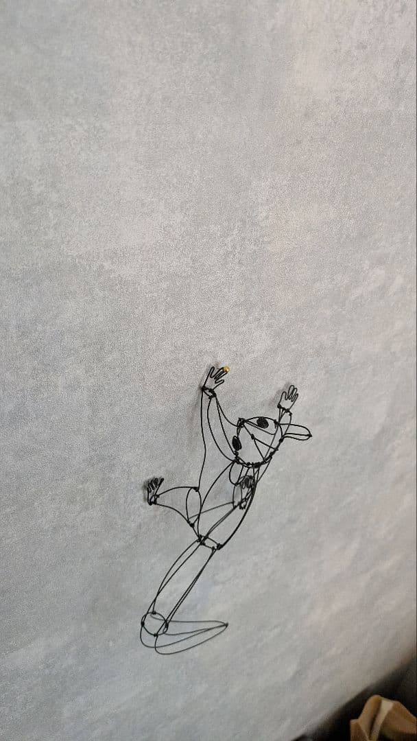 壁をのぼるフクロモモンガのワイヤーアート