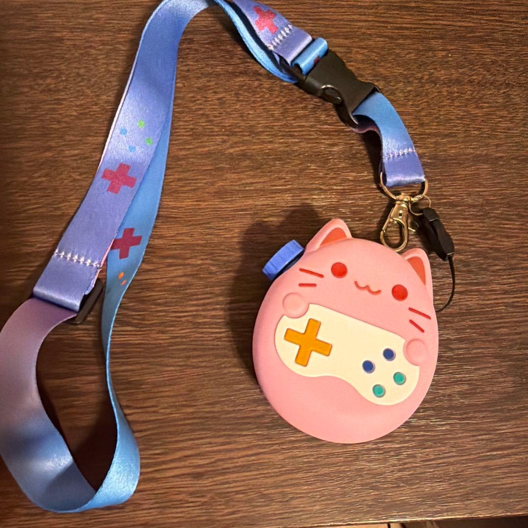 たまごっち本体、猫型ピンクカバー、ストラップ付き