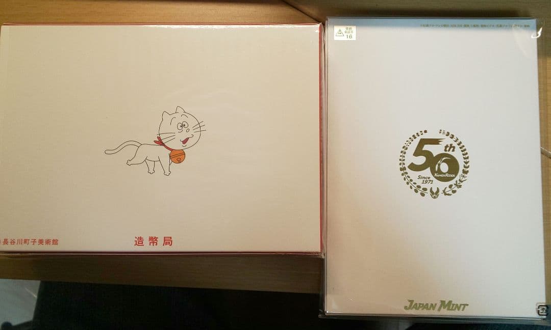 ①仮面ライダー生誕50周年貨幣セット 、②サザエさんアニメ放送50周年貨幣セット