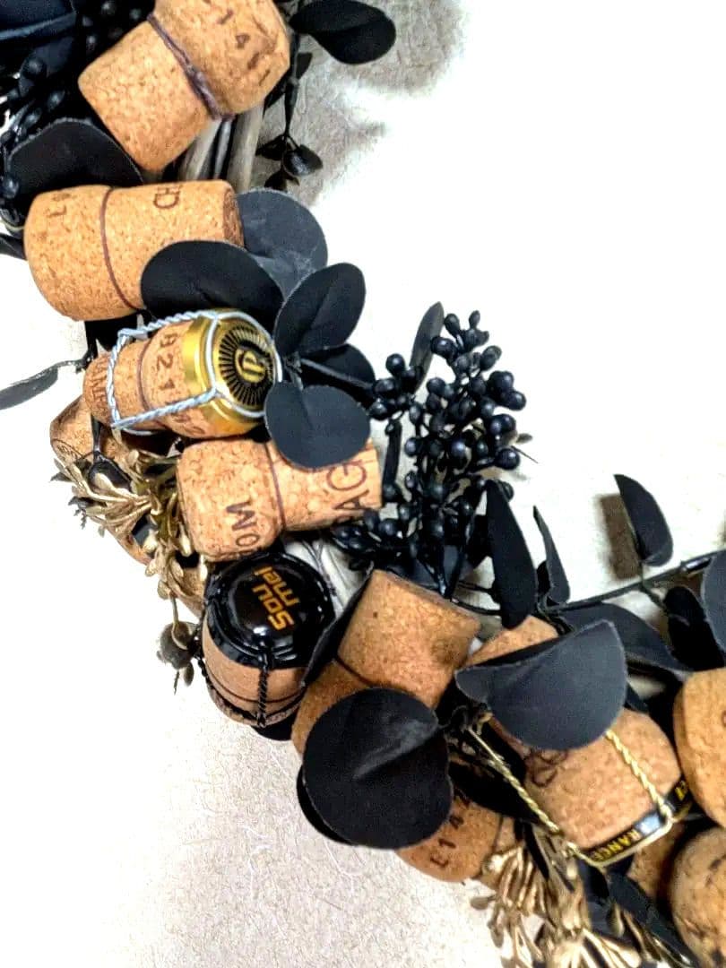 シャンパンコルクと黒い造花のリース