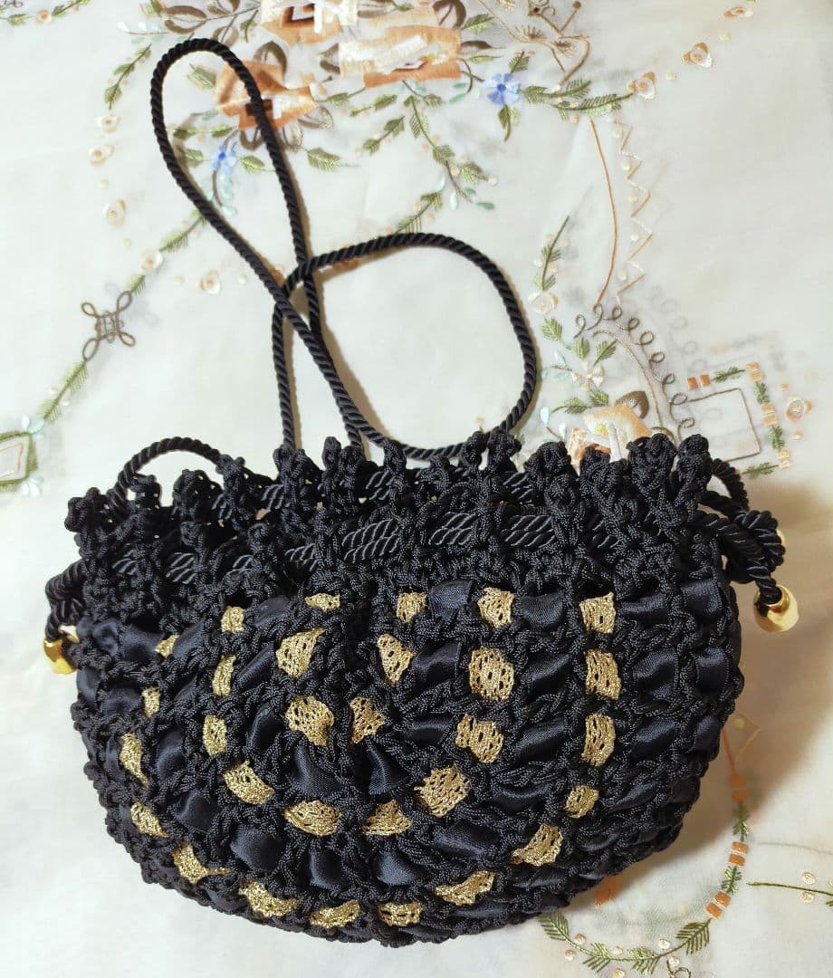 セール✨お洒落巾着型編みショルダーバッグ　未使用美品　黒　金色人気のリボン編み