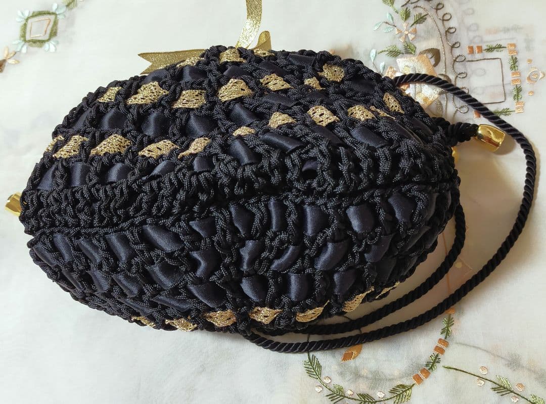 セール✨お洒落巾着型編みショルダーバッグ　未使用美品　黒　金色人気のリボン編み
