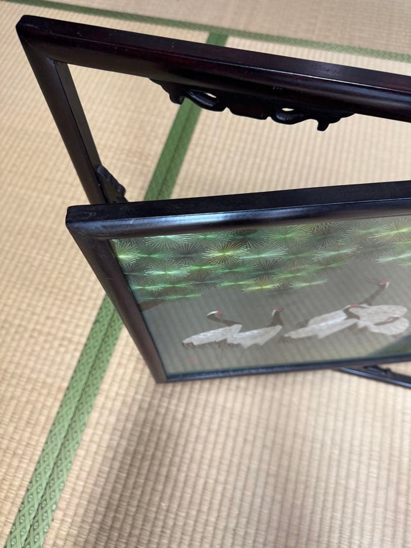 鶴の群れと松の木がデザインされた、額入りの手刺繍のアートワーク