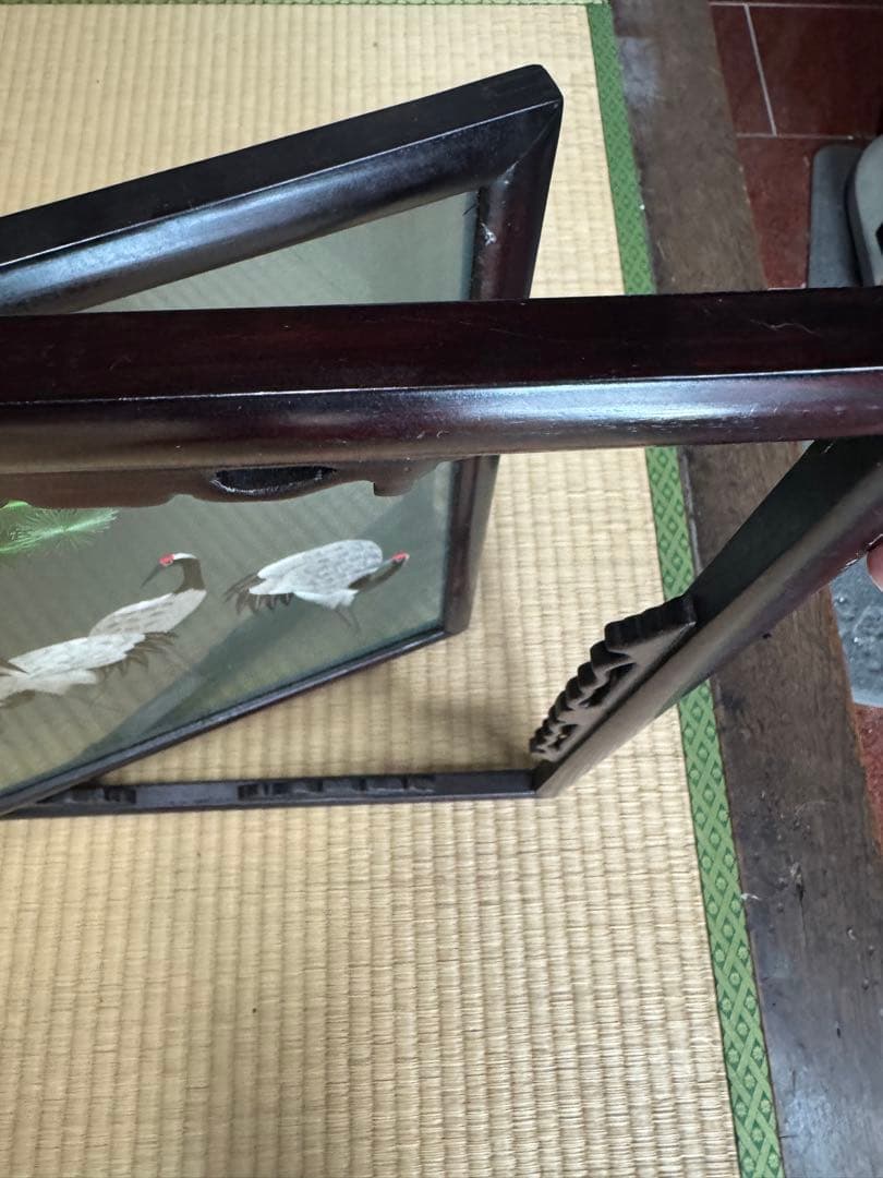 鶴の群れと松の木がデザインされた、額入りの手刺繍のアートワーク