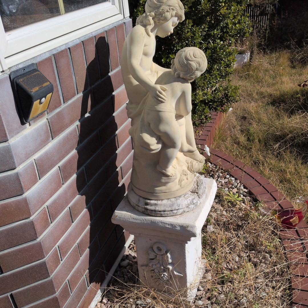 子供と本を読む少女の彫刻