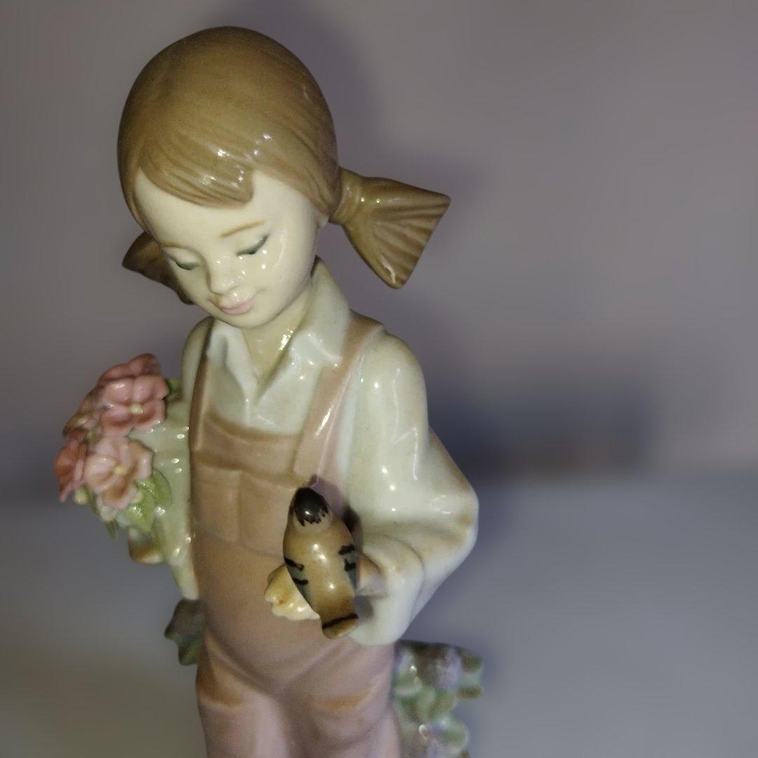 花お持つた少女。鳥と遊ぶ。